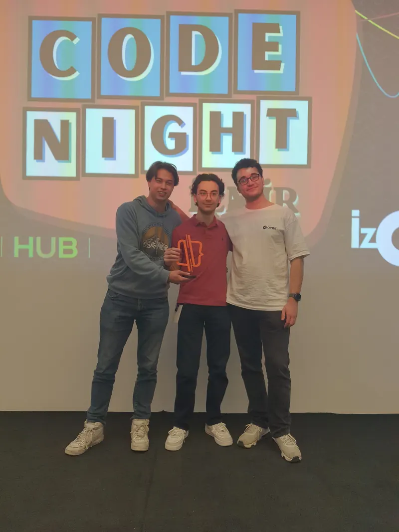 Code Night participants holding a trophy in front of the event backdrop