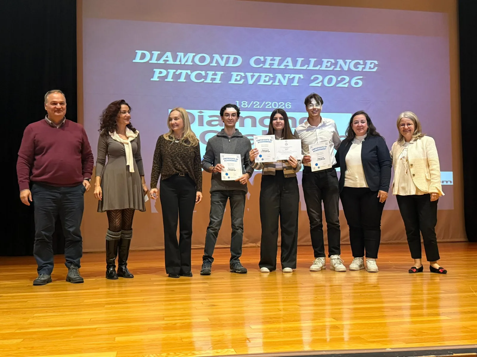 FarmerAI team and event participants on stage holding certificates at a Diamond Challenge pitch event